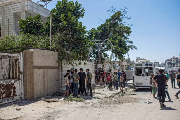 فلسطينيون قرب منزل مسؤول أمني في «حماس» تعرض لهجوم إسرائيلي أسفر عن اختطافه يوم الثلاثاء (إ.ب.أ)