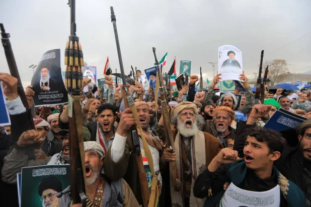 مسلحون حوثيون يرفعون صور خامنئي خلال حشد تعبوي في صنعاء (أ.ف.ب)