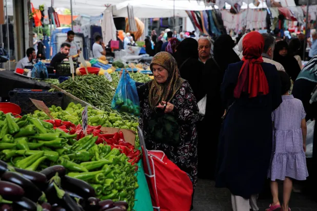 يتسوّق أشخاص في سوق للمواد الغذائية الطازجة في إسطنبول (رويترز)