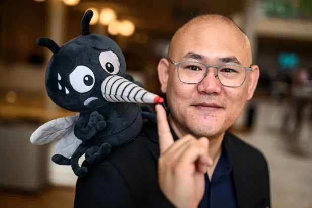 Canadian Associate Professor Changhong Cao poses with a fake mosquito ahead of the 2026 Ig Nobel Prize Ceremony in Zurich, on September 3, 2026. (AFP)