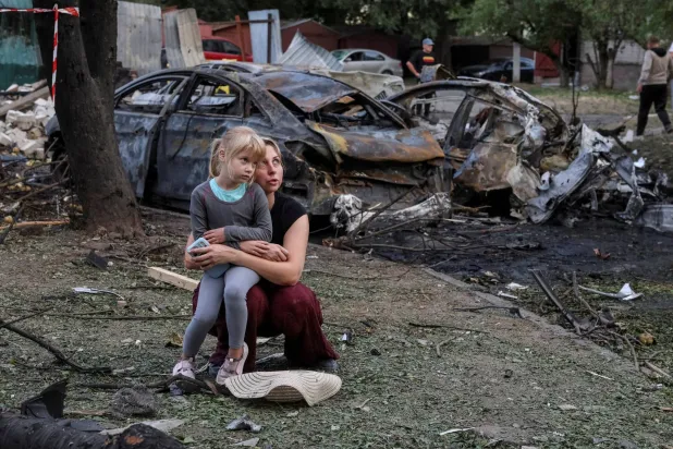 A resident Nataliia and her daughter Elia, 6, sit at a site of an apartment building damaged by a Russian missile strike, amid Russia's attack on Ukraine, in the town of Borispil, Ukraine September 1, 2026. REUTERS/Stringer  