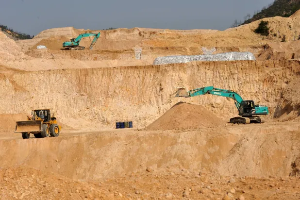 عمال يستخدمون آلات حفر في منجم للمعادن الأرضية النادرة بمقاطعة غانشيان في جيانغشي وسط الصين (أ.ب)