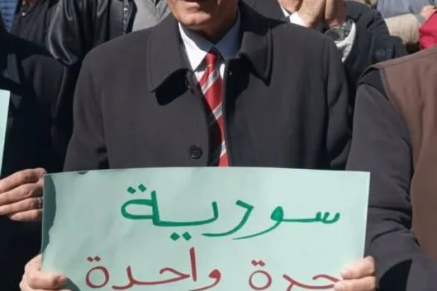 عاطف هنيدي وهو يشارك في مظاهرة في محافظة السويداء السورية (شبكة السويداء 24)