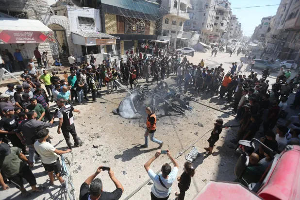 فلسطينيون يحيطون بسيارة محروقة إثر استهدافها بغارة في ضاحية تل الهوا في 31 أغسطس 2026 (د.ب.أ)