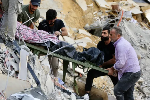 Yerel halk, Lübnan'ın güneyindeki Arap Salim kasabasında bir eve düzenlenen İsrail hava saldırısında hayatını kaybeden kurbanın cesedini taşıyor (EPA)