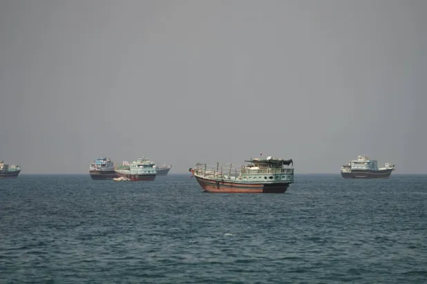 Dün Umman'ın Musandam eyaleti açıklarında Hürmüz Boğazı'nda demirlemiş gemiler ve tekneler (Reuters)