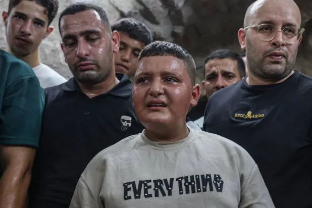 فتى فلسطيني يبكي يوم الاثنين خلال تشييع طالب طب الأسنان عمر طوباسي (20 عاماً) بعد مقتله برصاص مستوطنين إسرائيليين في قرية غرب مدينة نابلس بالضفة الغربية المحتلة (أ.ف.ب)