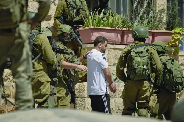
عناصر من القوات الإسرائيلية تعتقل فلسطينياً في أحد شوارع بلدة عناتا بالضفة الغربية المحتلة أمس (أ.ب)