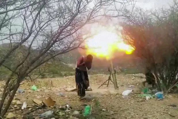 Batı Taiz'de Yemen hükümet güçlerine mensup bir savaşçı, havan mermisinin ateşlenmesi sırasında kulaklarını kapatıyor (AFP)