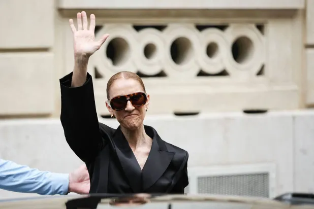 Canadian singer Celine Dion waves to fans as she exits Hotel Le Royal Monceau in Paris on September 3, 2026, ahead of a series of concerts in the French capital. (AFP)