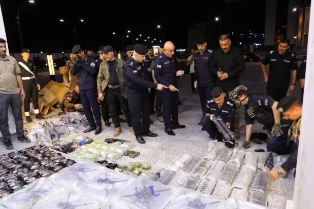 ضباط من الشرطة في الأنبار العراقية يعاينون مقذوفات ومسيرات تم ضبطها في المحافظة (إعلام أمني)