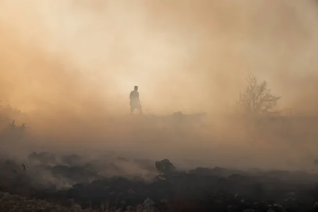 A firefighter inspects the area of a forest fire in Trebisevo, Bosnia and Herzegovina, September 7, 2026. (Reuters)