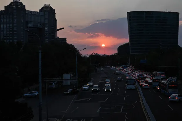 People commute as the sun sets in Beijing on September 12, 2026. (AFP)