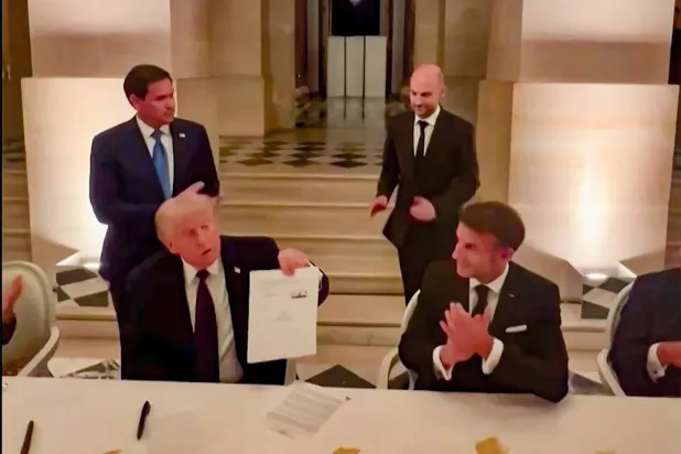Trump, 18 Haziran akşamı Versailles Sarayı'nda imzalanmasının ardından İran ile varılan "çerçeve anlaşma" belgesini gösteriyor. (AFP)