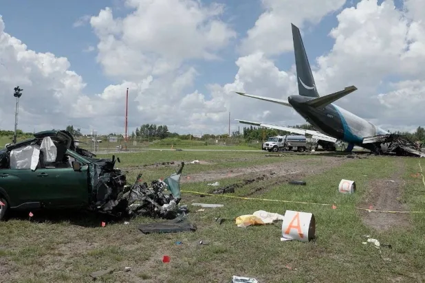 FILE PHOTO: A damaged car next to the wreckage of an Amazon Prime Air cargo plane overran a runway at Miami International Airport, in Miami, Florida, US, in this screengrab obtained from a handout video released on September 8, 2026. National Transportation Safety Board/Handout via REUTERS