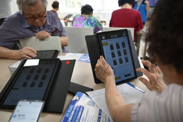 Elderly people using tablets during a government-organized digital survival training course at a senior community center in Suwon. Jung Yeon-je / AFP
