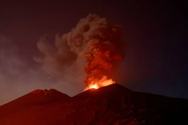Volcanic material and fumes rise from Mount Etna during an eruption under a starry sky in Sicily, Italy, July 30, 2026. (Reuters) 