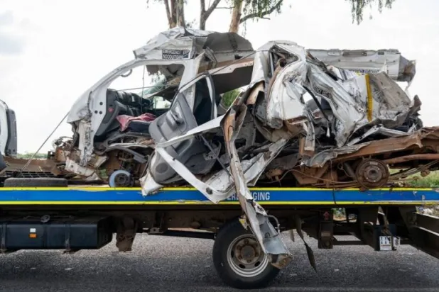 The remains of a mini bus taxi on a police tow truck at the scene of a fatal crash of 13 schoolchildren who perished ​when their minibus collided with a truck, in Johannesburg, South Africa, January 19, 2026. REUTERS/Shiraaz Mohamed