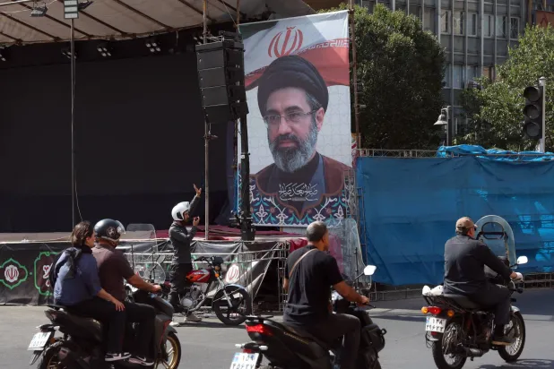 Iranians drive past a billboard of Iranian supreme leader Mojtaba Khamenei in a street in central Tehran, Iran, 13 September 2026. (EPA)