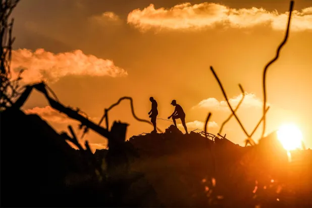 Men walk through rubble at the Bureij camp for Palestinian refugees in the central Gaza Strip on September 14, 2026. (AFP)