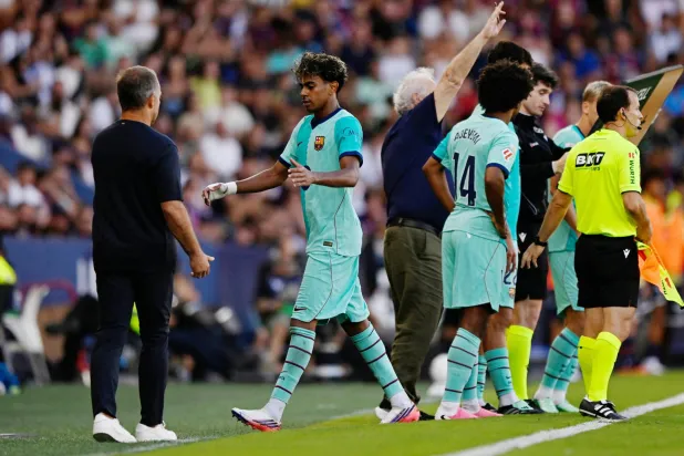 هانزي فليك مدرب برشلونة يصافح لاعبه لامين يامال (رويترز)