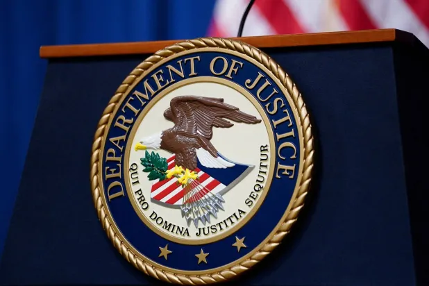 The seal of the US Justice Department is seen on the podium in the Department's headquarters briefing room in Washington, January 24, 2023. (Reuters)