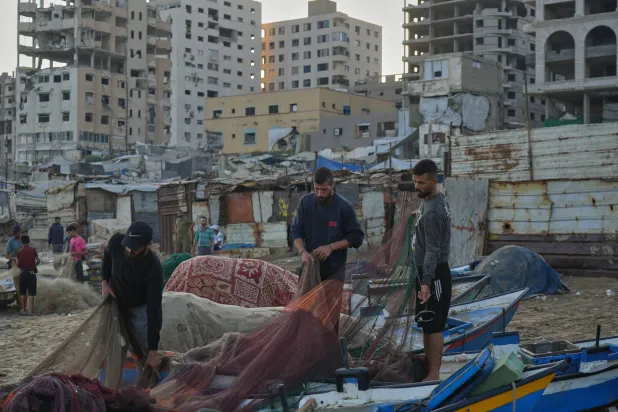 صيادون فلسطينيون يعملون على شباك صيدهم صباح الأحد 13 سبتمبر 2026 في ميناء مدينة غزة المتضرر من جراء الحرب (أ.ب)
