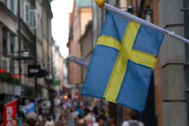 A Swedish flag hangs outside a store on a busy street as visitors walk past in the background in the old town of Stockholm, Sweden, July 14, 2023 REUTERS/Tom Little/File Photo Purchase Licensing Rights