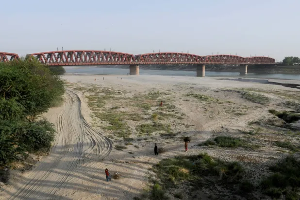 FILE PHOTO: People walk on the dry riverbed of the Indus River in Hyderabad, Pakistan April 24, 2025. REUTERS/Yasir Rajput/File Photo