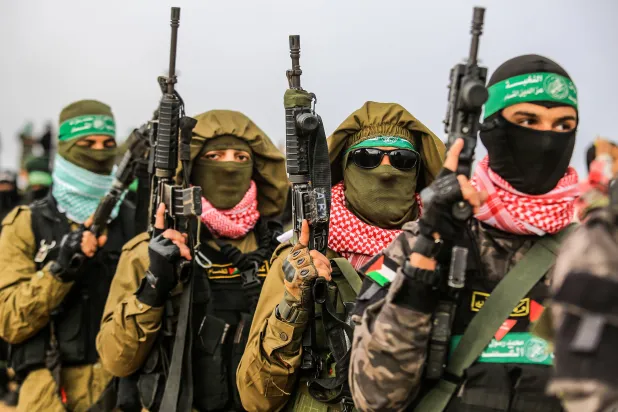 FILED - 20 February 2025, Palestinian Territories, Khan Younis: Fighters of the Ezz al-Din Al-Qassam brigade, the military wing of Hamas, stand guard during the hand over of the bodies of four Israeli hostages in Khan Yunis. Photo: Abed Rahim Khatib/dpa