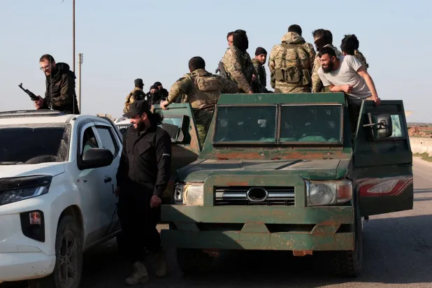 أفراد من الجيش السوري يتجهون نحو اللاذقية للانضمام إلى القتال ضد فلول الأسد في حلب (رويترز)