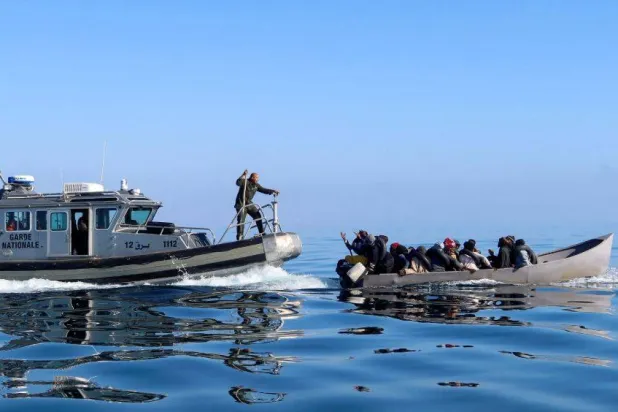 خفر السواحل التونسي يحاول إيقاف بعض المهاجرين في البحر أثناء محاولتهم العبور إلى إيطاليا (أرشيفية - رويترز)