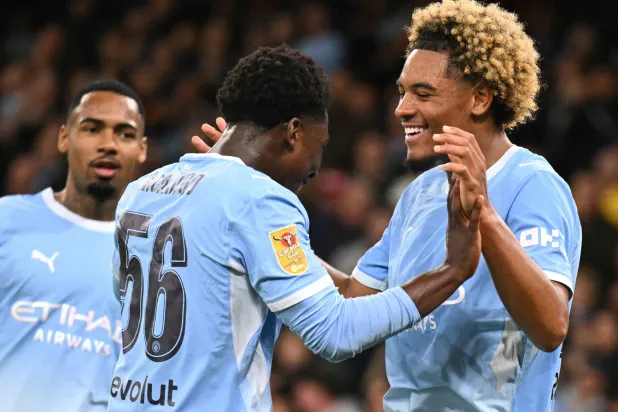 Manchester City's French midfielder #75 Floyd Samba (R) celebrates scoring the team's fourth goal with Manchester City's English midfielder #56 Ryan McAidoo during the English League Cup third round football match between Manchester City and Norwich City at the Etihad stadium in Manchester, northwest England on September 17, 2026. (Photo by Oli SCARFF / AFP)