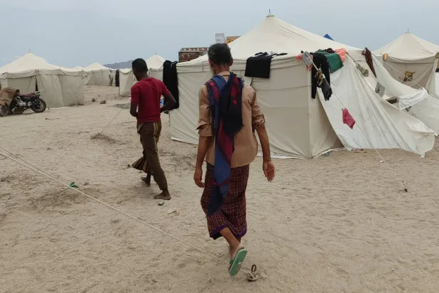  People walk past tents in al-Firdaws camp in Aden province, amid clashes between Iran-aligned Houthi fighters and Yemeni government forces, in Aden, Yemen, September 17, 2026. (Reuters)