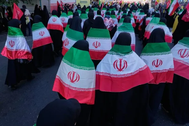  Women draped in Iranian flags march during the state-organized military-style parade in Tehran, Iran, Friday, Sept. 18, 2026. (AP) 