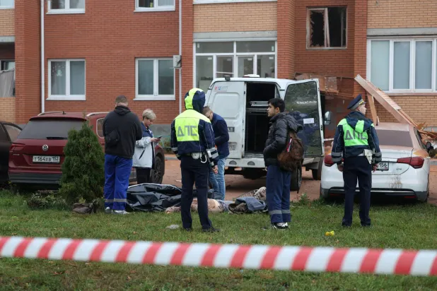 Emergency services personnel stand around the body of a victim killed in what authorities described as a Ukrainian drone strike on a residential building, amid the Russia-Ukraine conflict in Sofyino settlement in the Ramensky district of the Moscow region, Russia, September, 20, 2026. REUTERS/Stringer