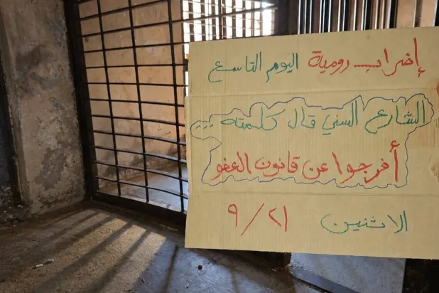 لافتة رفعها أحد المعتصمين في سجن رومية تدعو للإفراج عن قانون «العفو العام» (المركزية)