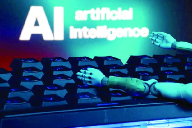 لوحة مفاتيح ويدا روبوت أمام عبارة «الذكاء الاصطناعي» باللغة الإنجليزية (رويترز)
