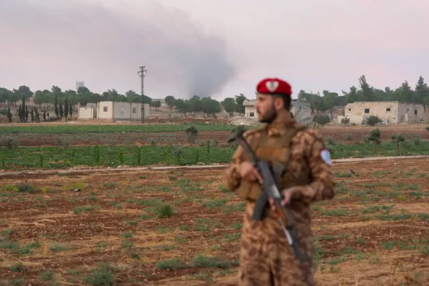 Halep’in güney kırsalındaki el-İys bölgesinde bir silah deposunda meydana gelen patlamanın ardından bir askeri polis memuru yol üzerinde bekliyor (Reuters)