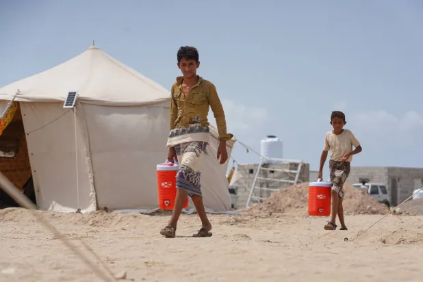  Displaced Yemenis carry water at Al-Firdaws camp in Ras Imran, on the western outskirts of Aden, Yemen, Monday, Sept. 21, 2026. (AP) 