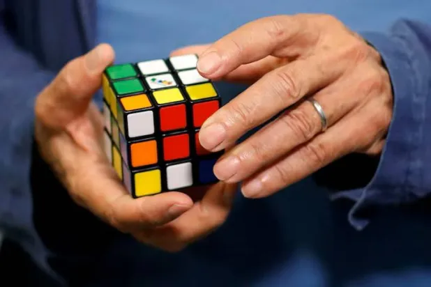 Erno Rubik, the creator of the puzzle, solves a Rubik's cube as he poses during the world's largest Rubik's Cube championship in Aubervilliers, near Paris, France, July 15, 2017. REUTERS/Stephane Mahe/File Photo