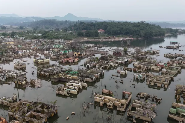 Long-submerged houses are exposed after prolonged drought lowers the water level of Karian Dam, in Lebak, Banten Province, Indonesia, Friday, July 31, 2026. (AP Photo/Tatan Syuflana)