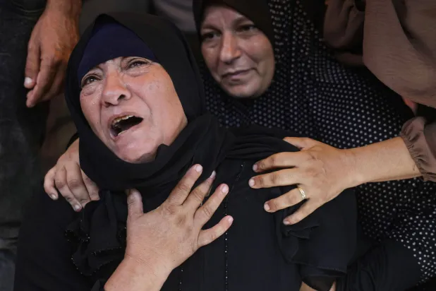 أم فلسطينية تبكي ابنها خلال جنازته الأربعاء بعد مقتله بغارة إسرائيلية في خان يونس جنوب غزة (أ.ف.ب)