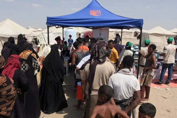 Çatışmalardan kaçan Yemenliler, dün Aden yakınlarında gıda kuponu almak için sırada bekledi (Reuters)