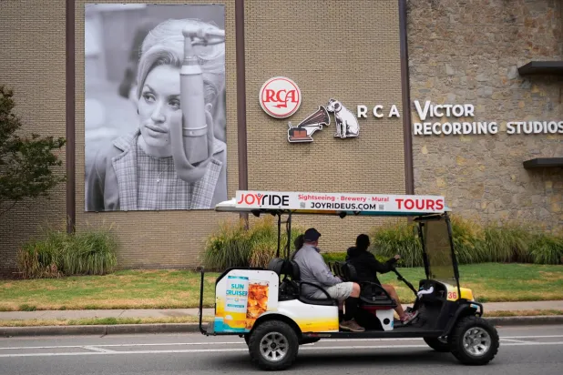 Tourists pass a portrait of the late Dolly Parton outside RCA Studio A, Wednesday, Sept. 23, 2026, in Nashville, Tenn. where Parton recorded "Jolene" and "I Will Always Love You" during a 1973 recording session. (AP Photo/George Walker IV)
