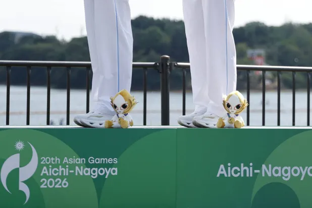Asian Games - Aichi-Nagoya 2026 - Canoeing - Miyoshi Lake Canoe Course, Miyoshi, Japan - September 24, 2026 The plushie of Aichi-Nagoya 2026 mascot Honohon as gold medallists China's Shimeng Yu and Mengdie Yin celebrate on the podium after winning the Women's Kayak Double 500m REUTERS/Bryan Foo