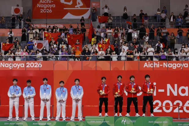 Asian Games - Aichi-Nagoya 2026 - Table Tennis - Men's Team Final - Sky Hall Toyota, Toyota, Japan - September 24, 2026   Gold medallists Japan's Tomokazu Harimoto, Sora Matsushima, Shunsuke Togami, Yukiya Uda and Hiroto Shinozuka celebrate on the podium after winning the Men's Team Final with silver medallists China's Youzheng Huang, Shidong Lin, Chuqin Wang, Ruibo Wen and Peng Xiang REUTERS/Andrew Couldridge