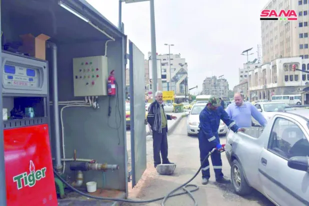 FILE - This file photo released on April 7, 2019, by the Syrian official news agency SANA, shows a worker filling a pickup at a gas station, in Homs, Syria. (SANA via AP, File)