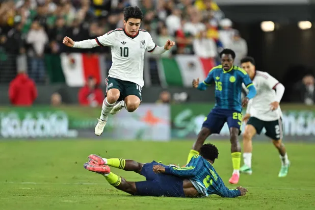 غيلبرتو مورا لاعب المكسيك يقفز فوق الكولومبي ألفارو أنغولو لتفادي تدخُّل خلال المباراة الودية بين المنتخبين في بالتيمور (أ.ف.ب)