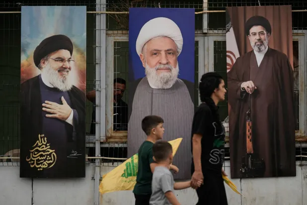 صورة لنعيم قاسم متوسطاً سلفيه حسن نصر الله وهاشم صفي الدين خلال الذكرى الثانية لاغتيالهما (أ.ب)